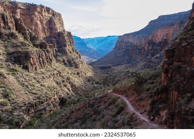 Panoramic aerial view from Bright Angel hiking trail at South Rim of Grand Canyon National Park, Arizona, USA. Vista after sunrise in summer. Colorado River weaving through valleys and rugged terrain - Powered by Shutterstock