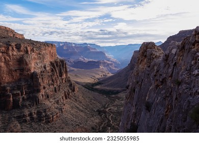 Panoramic aerial view from Bright Angel hiking trail at South Rim of Grand Canyon National Park, Arizona, USA. Vista after sunrise in summer. Colorado River weaving through valleys and rugged terrain - Powered by Shutterstock