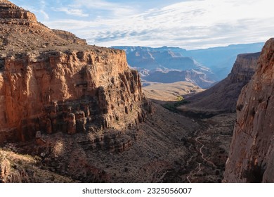 Panoramic aerial view from Bright Angel hiking trail at South Rim of Grand Canyon National Park, Arizona, USA. Vista after sunrise in summer. Colorado River weaving through valleys and rugged terrain - Powered by Shutterstock