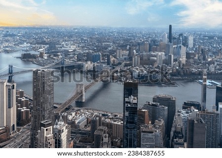 Panoramic aerial view of the Brooklyn Bridge stretching over East River, with the cityscape of Brooklyn in the backdrop.