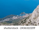 Panoramic aerial view of coastal town Makarska seen from skywalk in Biokovo nature park, Dalmatia, Croatia. Majestic karst coastline of Adriatic Mediterranean sea in summer. Tranquil serene atmosphere