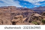 Panoramic aerial view of Colorado River weaving through valleys and rugged terrain seen from Plateau Point, Bright Angel Trail, South Rim, Grand Canyon National Park, Arizona, USA. Brown dirty water