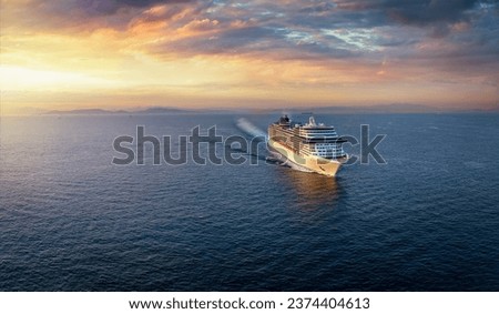 Panoramic aerial view of a cruise ship traveling over the ocean during golden summer sunset time with copy space