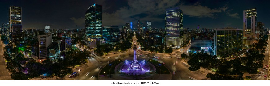 Panoramic aerial view of the famous Reforma avenue full of trees and huge office buildings illuminated by the night lights of the city - Powered by Shutterstock