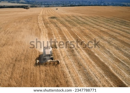 Similar – A combine harvester is harvesting grain crops on a cornfield in the evening sun seen from above