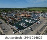 Panoramic aerial view of Hythe Marina Village in New Forest, UK. Green landscape by the sea. First of its kind that was build in the UK. Sailing boats moored next to residential houses.