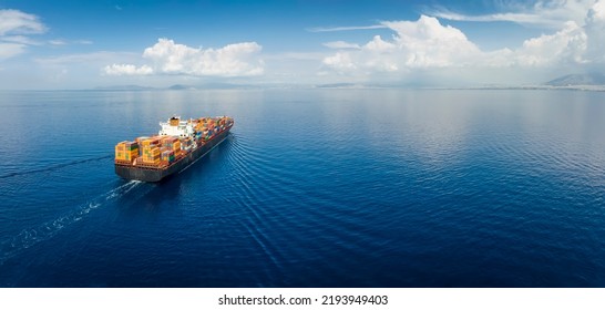 Panoramic aerial view of a industrial cargo container ship traveling over calm, open sea with copy space - Shutterstock ID 2193949403