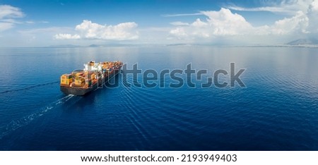 Panoramic aerial view of a industrial cargo container ship traveling over calm, open sea with copy space