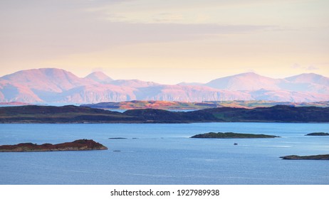 Panoramic aerial view of the isles of Jura and Mull at sunrise. Pure sunlight above the forests and hills. Loch Craignish, Crinan Canal, Scotland, UK. Travel destinations, tourism, nature, landscape