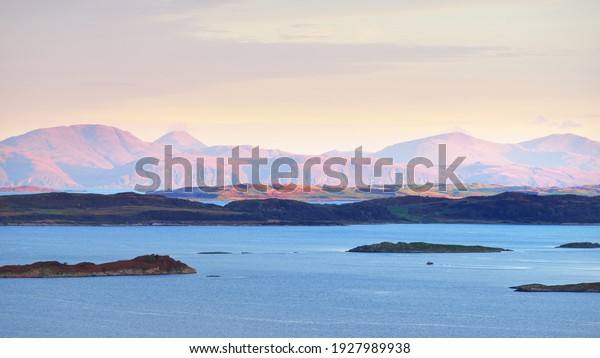 Panoramic aerial view of the isles of Jura and\
Mull at sunrise. Pure sunlight above the forests and hills. Loch\
Craignish, Crinan Canal, Scotland, UK. Travel destinations,\
tourism, nature,\
landscape