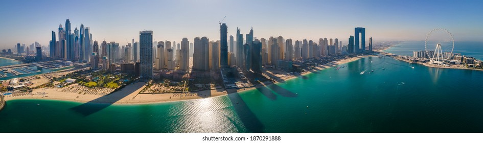 Panoramic aerial view of JBR beach and Dubai Marina skyscrapers and luxury buildings in one of the United Arab Emirates travel spots and resorts in Dubai