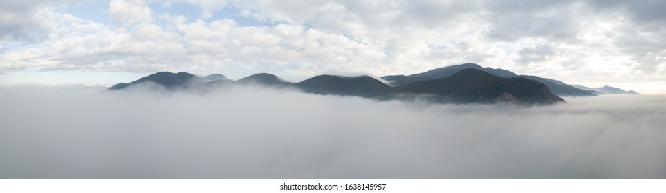 Panoramic aerial view of a mountain in the fog, Tuscany, Italy.
