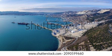 Panoramic aerial view of Novorossiysk, seaport, oil and gas terminal Sheskharis on sunny winter day. Black Sea, Krasnodar Krai, Russia