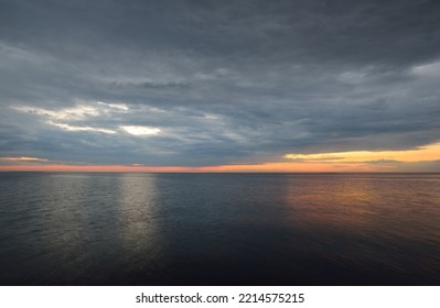 Panoramic Aerial View From A Rocky Baltic Sea Shore After The Rain At Sunset. Golden Sunlight, Glowing Clouds, Dramatic Blue Sky. Idyllic Seascape. Nature, Environment, Climate, Weather