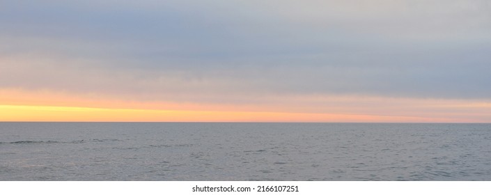 Panoramic Aerial View From A Sandy Baltic Sea Shore After The Rain At Sunset. Golden Sunlight, Colorful Glowing Clouds. Idyllic Seascape. Ventspils, Latvia