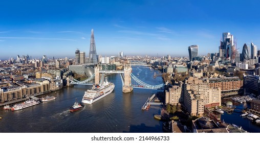 Panoramic aerial view of the skyline of London with the lifted Tower Bridge and a cruise ship passing under - Shutterstock ID 2144966733