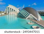 Panoramic aerial view of the stunning architectural features of the City of Arts and Sciences, set against the azure sky and serene waters in Valencia, Spain.