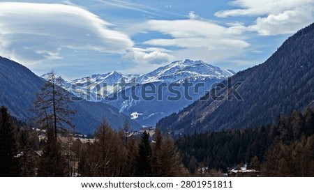 Panoramic Alpine Valley with Lenticular Clouds and Snowy Peaks