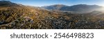 Panoramic autumn aerial drone view in evening light across the towns of Savièse and Sion in the Rhone Valley, canton of Valais in Switzerland, overlooking the Pennine Alps, including Dent Blanche