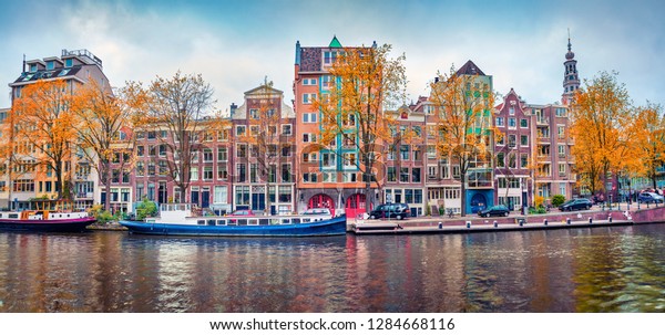 アムステルダム市のパノラマ秋の景色 有名なオランダの水路と素晴らしい都市景観 ヨーロッパのオランダの華やかな朝の風景 旅のコンセプトの背景 の写真素材 今すぐ編集