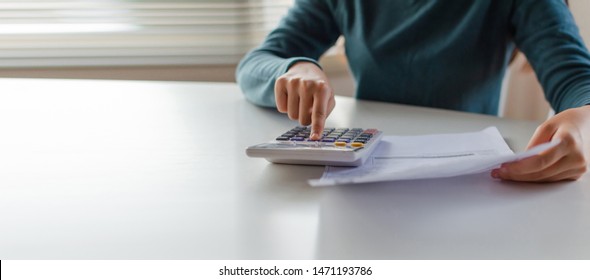 Panoramic Banner. Hand Of Young Woman Using Calculator For Calculating Family Budget Cost Bills On Desk In Home Office, Plan Money Cost Saving, Investment, Business Finance, Expenses, Income Concept