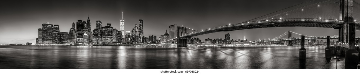 Panoramic Black and white view of Lower Manhattan Financial District skyscrapers at twilight with the Brooklyn Bridge and East River. New York City - Powered by Shutterstock