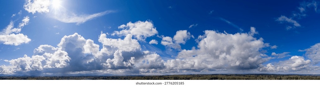 Panoramic blue sky filled with dramatic white clouds over a mountain horizon — Cloudscape in British Columbia, Canada.
