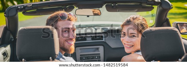 Panoramic car road trip\
tourists couple happy driving convertible on travel vacation banner\
panorama.
