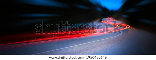 Panoramic - Cars light trails at\
night in a curve  asphalt road at night, long exposure\
image
