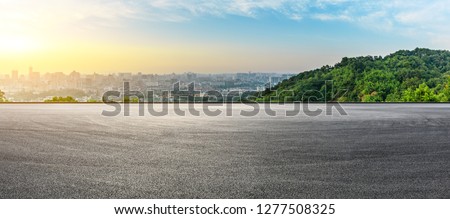 Panoramic city skyline and buildings with empty asphalt road at sunrise