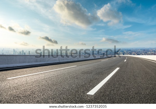 Panoramic city skyline and buildings with empty\
asphalt road