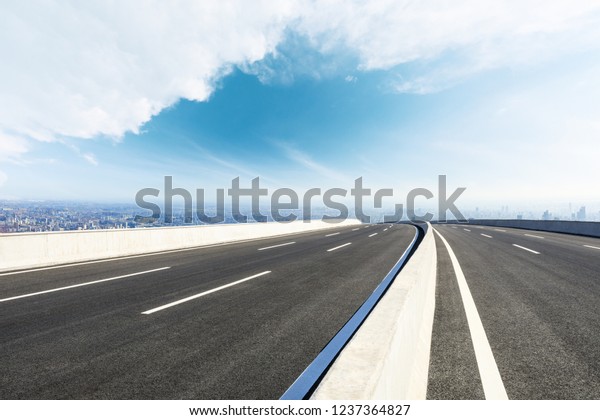 Panoramic city skyline and buildings with empty\
asphalt road