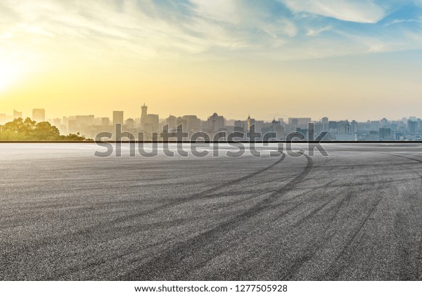 Panoramic city skyline and buildings with empty\
asphalt road at\
sunrise