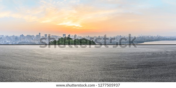 Panoramic city skyline and buildings with empty\
asphalt road at\
sunrise