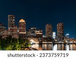 Panoramic city view of Boston Harbour and Seaport Blvd evening and night time, Massachusetts. An intellectual, technological and political center.