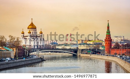 Panoramic cityscape with beautiful Cathedral of Christ the Saviour and Kremlin Vodovzvodnaya Tower view from Moskva River golden sunrise Moscow Russia