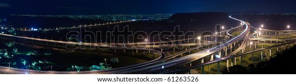 Panoramic cityscape of freeway in night\
with cars light in modern city in Taiwan,\
Asia.