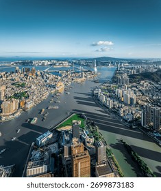 Panoramic cityscape of the inner harbor separating the two bustling cities on a clear sunny day in Macau.