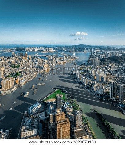 Panoramic cityscape of the inner harbor separating the two bustling cities on a clear sunny day in Macau.