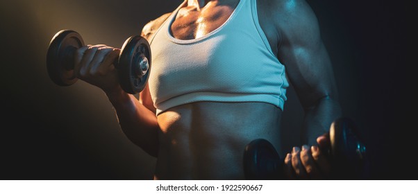 Panoramic Close Up Shot Of Body Builder Female Athletes Lifting Dumbbell With Hot Tone Lighting With Fog Atmosphere In The Background. Selective Focused. Self Challenge, Muscular Woman.