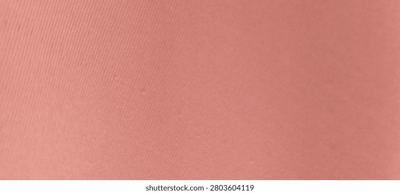 Panoramic close up of smooth light pink synthetic fabric with a subtle ribbed texture. High angle abstract minimalist background featuring peach or salmon colored elastic spandex textile material surface for wide banner design.
