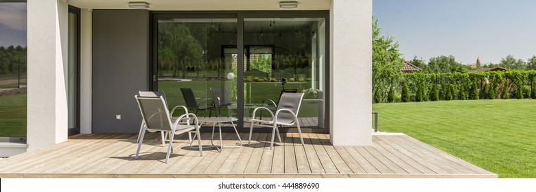 Panoramic Close-up Of A Terrace In A Modern Suburban House, With Board Deck And Garden Furniture