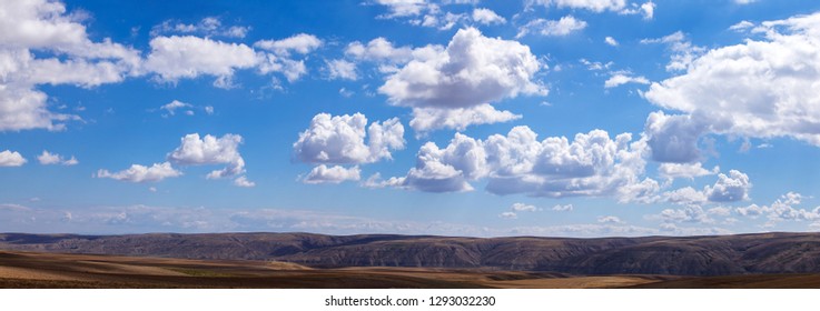 Panoramic clouds over hills and fields