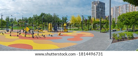 Panoramic of colorful large playground in city park. Empty modern outdoor playground in springtime. Beautiful urban place for kids games and sport