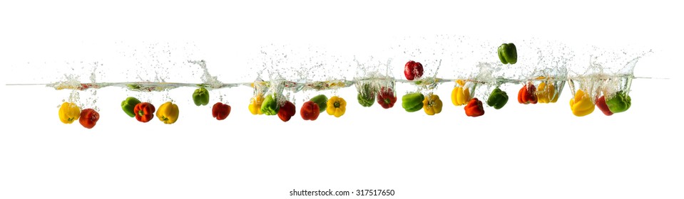panoramic composite image of various coloured peppers splashing in the water, can be used for large format printing. Isolated on white background.