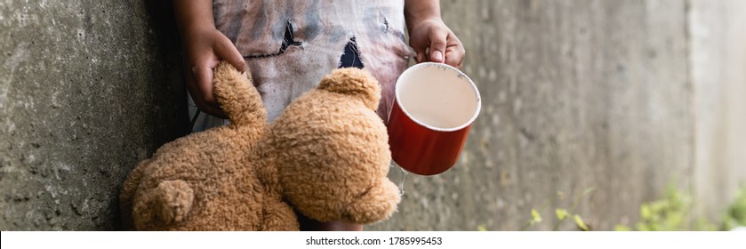 Panoramic Crop Of Beggar African American Child Holding Teddy Bear While Begging Alms On Urban Street