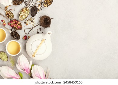  A panoramic display of different types of tea leaves and brewed tea in cups, with a delicate magnolia blossom adding a touch of spring freshness to the scene. Banner