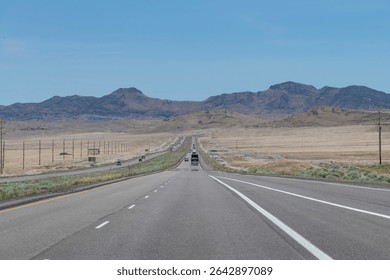 Panoramic drivers view over Interstate 80 or Dweight D Eisenhower Highway in the desert in Easterly direction from Salt Lake City, UT, USA to Wendover with mountain range on horizon
