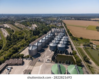 Panoramic elevated perspective of extensive industrial agroindustrial grain storage facility next to agricultural fields.