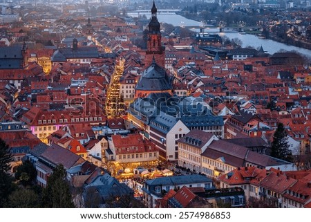 Panoramic, elevated view of the festive decorated old town of Heidelberg, Germany, around the Heiliggeistkirche during winter dusk